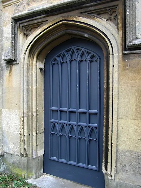 A new Gothic-arched timber door in an old stone doorway